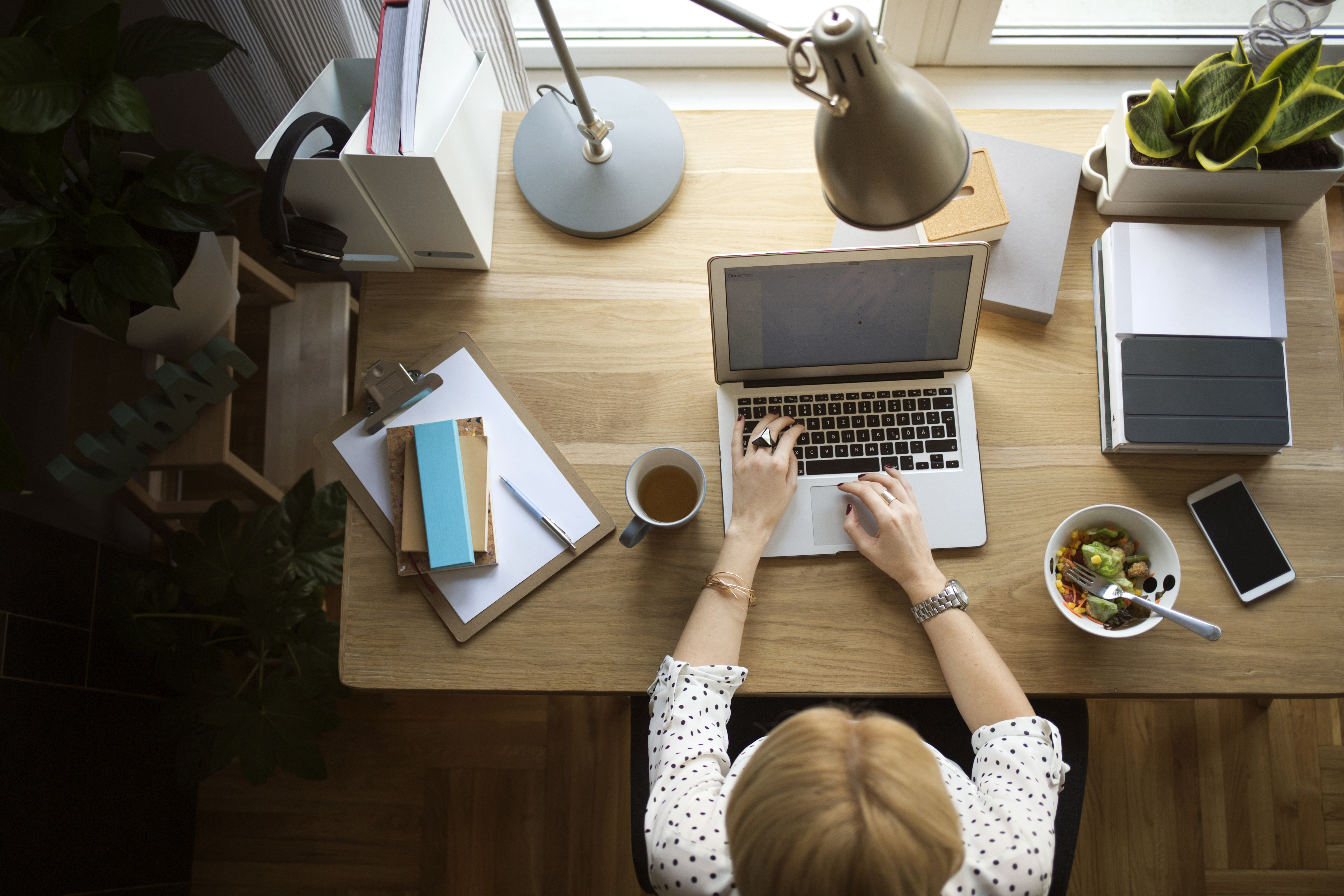 A woman is sitting at a desk using a computer.